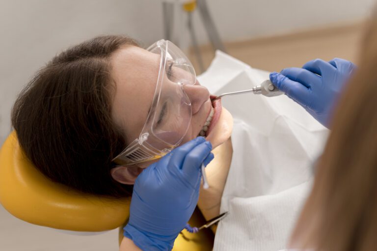 Dentista revisando encías del paciente durante limpieza profunda